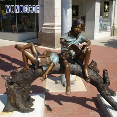 Custom Life Size Bronze statues of companions sitting on arched tree trunks reading together