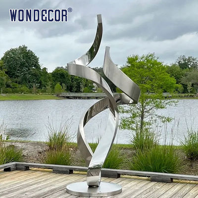 Large forged metal shaped twisted geometric stainless steel sculpture in the park