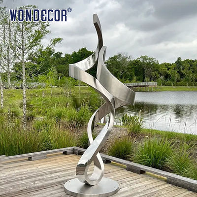 Large forged metal shaped twisted geometric stainless steel sculpture in the park
