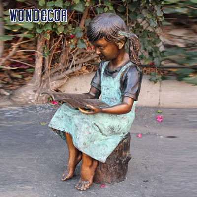 Custom Life Size A bronze statue of a girl reading on a tree stump